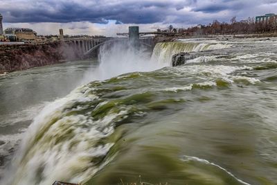 Scenic view of waterfall against sky