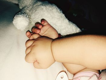 Low section of baby lying on hand