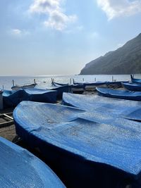 Boats moored on beach against sky