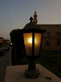 Illuminated street light on wall at night