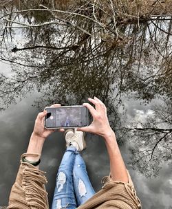 Low section of person photographing on mobile phone