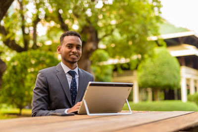 Young man smiling while sitting on table