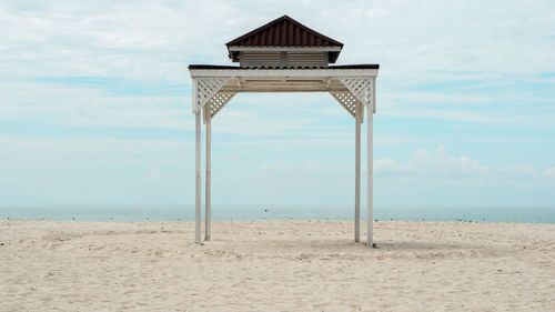 Lifeguard hut on beach against sky