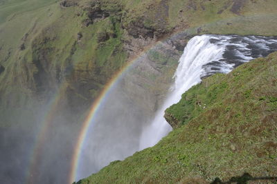 Scenic view of rainbow over stream