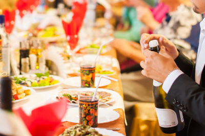 Midsection of man holding wine bottle