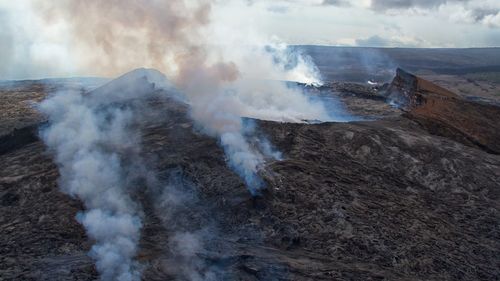 Smoke emitting from volcanic mountain against sky