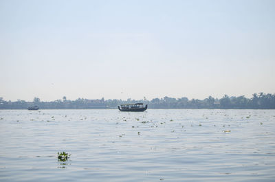 Boat sailing in sea against clear sky