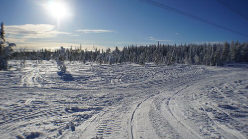 Scenic view of snow covered field against sky