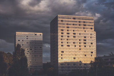 Low angle view of buildings against cloudy sky