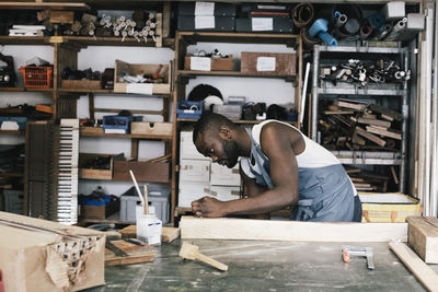 Male entrepreneur upcycling wood at workshop