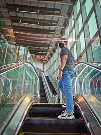 Low angle view of man standing on escalator