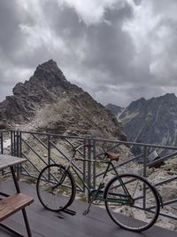 Bicycle by mountain against sky