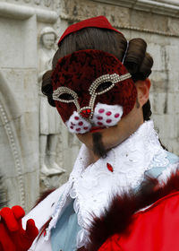 Portrait of man wearing mask and costume in city
