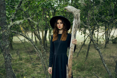 Portrait of young woman standing in forest