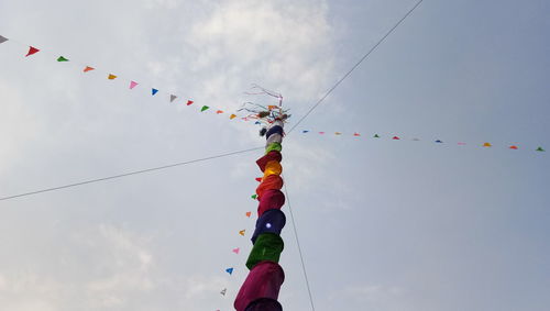 Low angle view of prayer flags on pole against sky