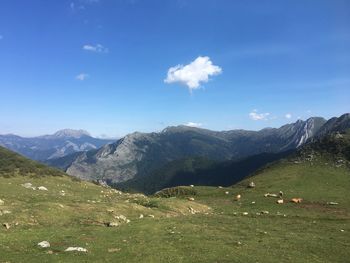 Scenic view of landscape and mountains against blue sky