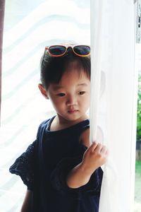 Portrait of cute boy standing against wall