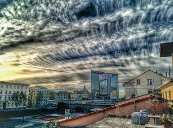 Buildings in city against cloudy sky