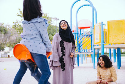 Mother with cheerful daughters enjoying at park