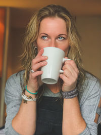 Portrait of young woman drinking coffee