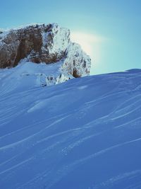 Scenic view of snow covered mountain against blue sky