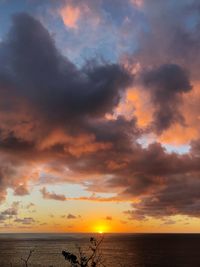 Scenic view of sea against dramatic sky during sunset