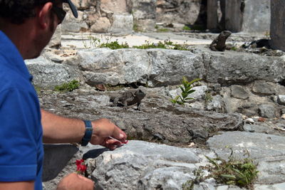 Side view of man holding rock