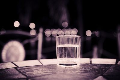 Drinking water in glass on table at home