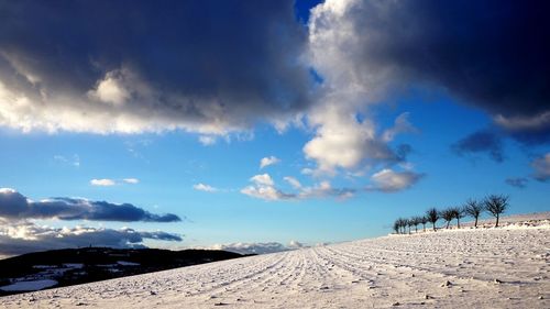 Scenic view of landscape against blue sky during winter