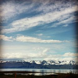 Scenic view of mountain range against cloudy sky