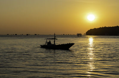 Silhouette boat in sea against sky during sunset