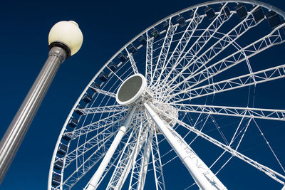 Low angle view of ferris wheel against blue sky