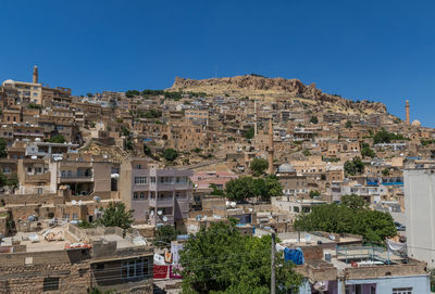 Buildings in town against clear blue sky