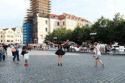 People on street in city against sky