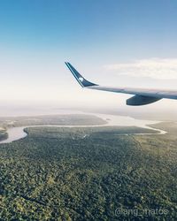 Airplane flying over landscape against sky