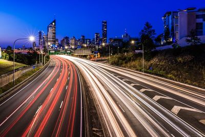 Light trails on road against clear sky at night