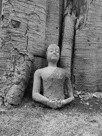 Old statue against stone wall