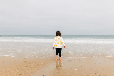 Rear view of man standing on beach