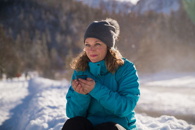 Young woman using mobile phone during winter