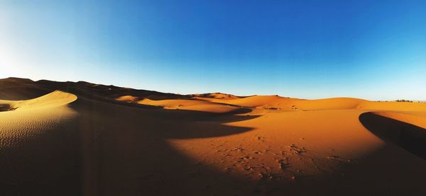 Scenic view of desert against clear blue sky