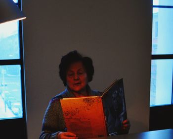 Woman reading menu while sitting in restaurant