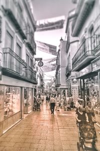 People walking on street amidst buildings in city