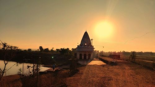 Church by building against sky during sunset