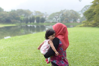 Mother and daughter standing on grass
