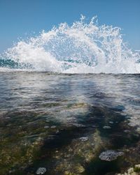 Waves splashing in sea against sky
