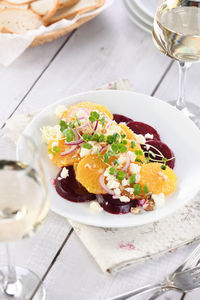 Orange salad with baked beetroot, goat cheese, microgreens and nuts.  