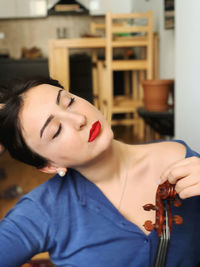 Portrait of young woman with eyes closed at home