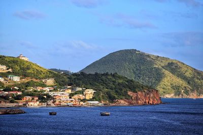 Scenic view of sea by mountains against sky