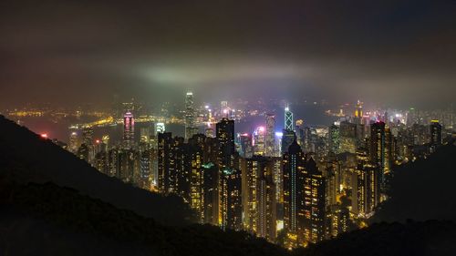 Illuminated cityscape against sky at night