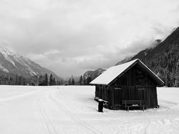 Built structure on snow covered landscape against sky